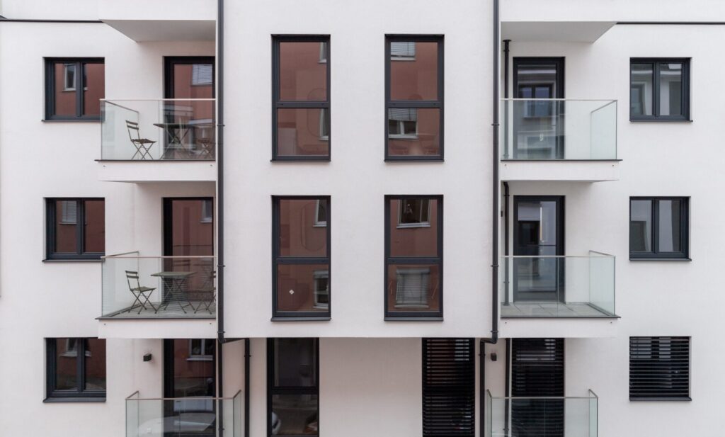 Fassadenansicht der sanierten Wohnhausanlage Aichhorngasse 10 in Wien mit Balkonen und Fenstern